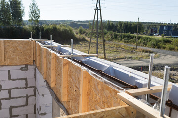 Construction Site Detail: Close-up of Wooden Formwork and Rebar for Concrete Foundation with Rural Landscape