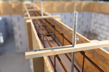 Reinforced Concrete Formwork with Metal Rebar Grid in Wooden Frame on Aerated Block Wall Construction Site