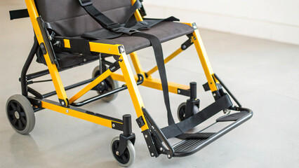 Disability advocacy concept. Lightweight transport chair with yellow and black features.