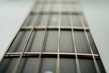 Close-up image of a guitars fretboard, highlighting meticulous craftsmanship and frets for accurate...