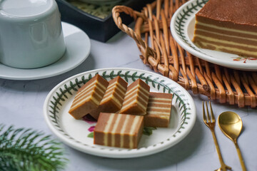 A traditional Indonesian steamed layer cake with alternating vibrant layers, showcasing a soft,...
