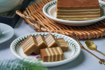 A traditional steamed layer cake with alternating vibrant layers, showcasing a soft, moist texture...