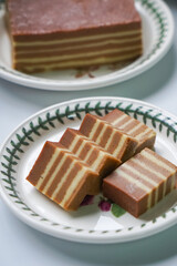 A traditional Indonesian steamed layer cake with alternating vibrant layers, showcasing a soft, moist texture and rich flavors, perfect for festive occasions.