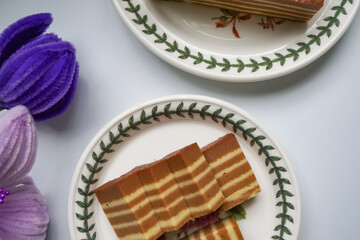 A traditional steamed layer cake with alternating vibrant layers, showcasing a soft, moist texture and rich flavors, perfect for festive occasions.