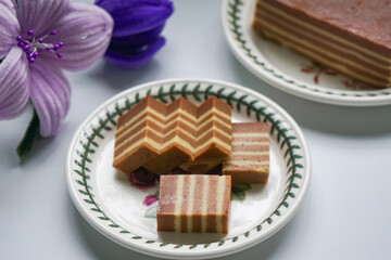 A traditional steamed layer cake with alternating vibrant layers, showcasing a soft, moist texture...