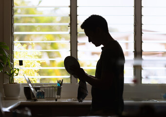 Sad father at home washing dishes 