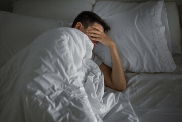 Sleepless man lying in bed feeling tired depressed 
