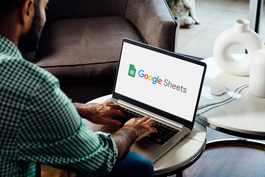 Man using a laptop computer displaying logo of Google Sheets on the screen. Online spreadsheet software for calculate, formulas and productivity. ROSARIO, ARGENTINA - APRIL 17, 2025
