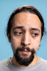 Confused distraught young man feeling troubled and anxious in studio, feeling overwhelmed in disappointment. Stressed male person scared and worried, uncertainty and desolation.