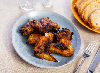 Cooked and served on plate appetizing chicken wings for dinner