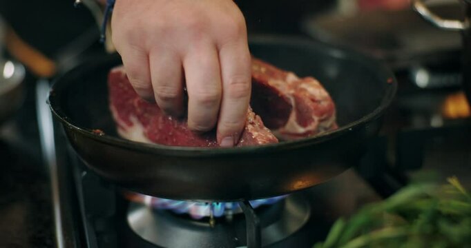 Cooking, hands and steak in frying pan in kitchen for meal preparation, enhance flavor and render beef fat. Chef, person and meat recipe in home for healthy protein, nutrition and food for wellness