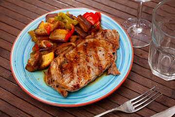 Grilled beef steak served with baked vegetables at plate, nobody