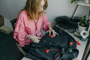 Woman making a decoration with hearts on shirt