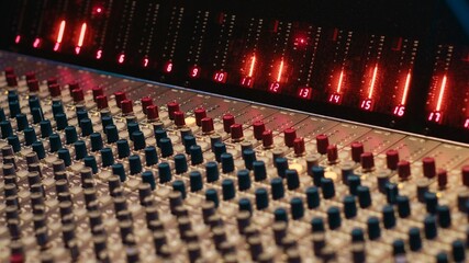 Control room desk equipped with motorized faders and amplifier used in mixing and mastering tracks...