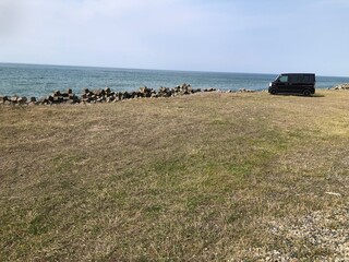 日本海、海、砂浜、砂利道、水たまり、波、波際、テトラポット、防波堤、サビ、家事、突風、石、水、太陽、日差し、さわやか、初夏、夏、春、流木、荒波、おだやか、濃い頃、大きい、広い、葉は、壮大、蔭、人間、男性、歩く、散歩委、しぃうみ、ドライブ、余暇、休日、