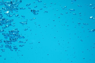 Many water bubbles on blue background, closeup