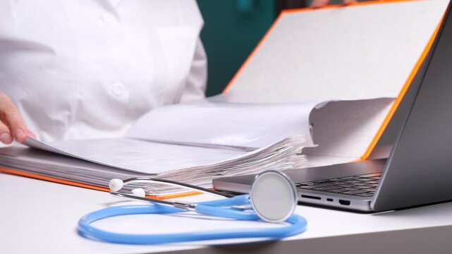 Doctor consulting patient medical records on laptop with stethoscope