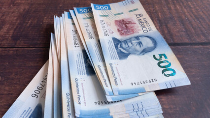 Group of Mexican $500 bills placed on a wooden table, vertical shot