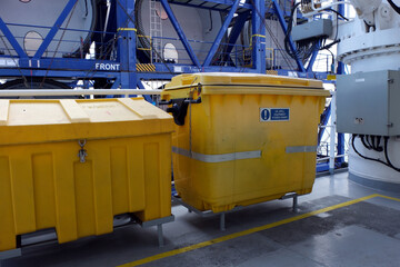 Two yellow SOPEP spill kit as a part of the ship oil pollution emergency plan situated on deck of merchant ship.