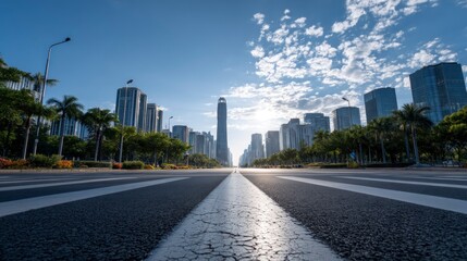 Obraz premium Driving on Empty Road Leading to Modern City Skyline with Blue Sky