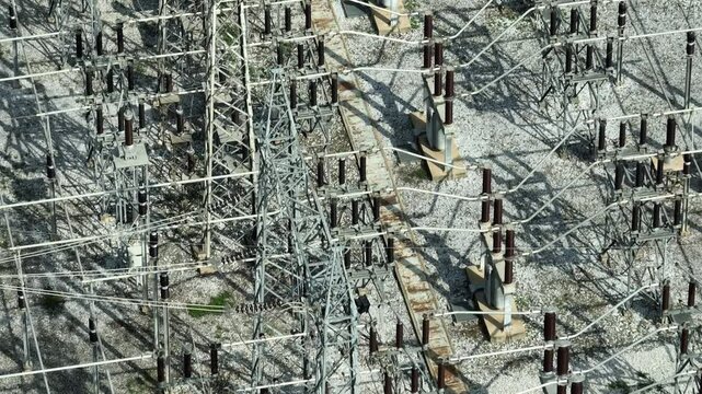 A high-angle drone shot of a power substation, highlighting the interconnected network of transformers and power lines that ensure electricity distribution.
