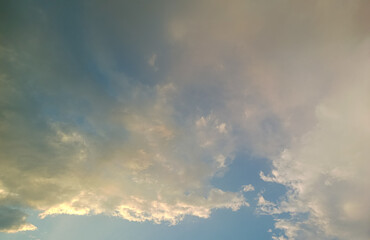 Expansive sky view with a blend of blue and soft golden hues. Wispy clouds spread across, capturing subtle light variations, suggesting early morning or late afternoon.