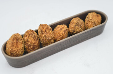 Ración de croquetas variadas rellenas de pollo, jamón y mariscos.