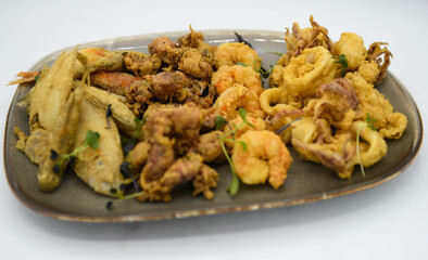 Diferentes trozos fritos de marisco y pescado, rebozados con harina.