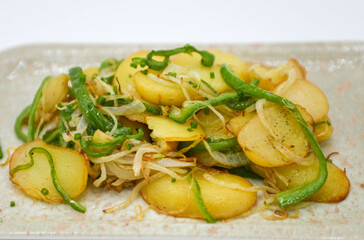 Patatas al horno con ajo y sal en un plato sobre fondo blanco.