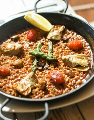 Paella vegetariana con espárragos, tomate y champiñones - estilo comida italiana
