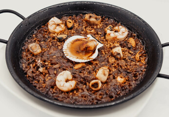 Paella de marisco con una vieira en una marisquería