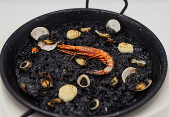 Paella de arroz negro con gambas, almejas y mejillones
