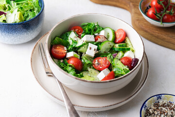 Greek salad with fresh tomatoes, cucumbers, lettuce, feta cheese and seeds.