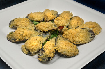 cozze ripiene gratinate servite su di un piatto di carta