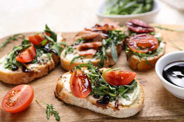 Wooden board with delicious sandwiches, closeup