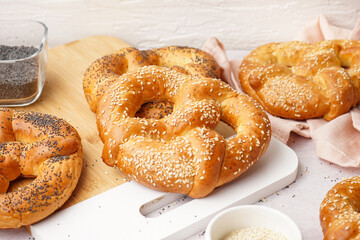 Board with tasty pretzels on light table, closeup