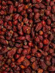 dried rosehip fruits scattered, filled with rosehip berries. dry rosehip fruits fill the frame with a scattering. rosehip berries are useful for colds.