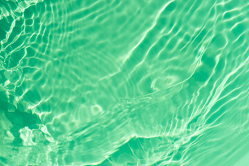 Blue water with ripples on the surface. Defocus blurred transparent blue colored clear calm water surface texture with splashes and bubbles. Water waves with shining pattern texture background.