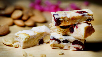 dessert shop Nutty nougat Delicious nougat pieces with nuts and fruit, set on a wooden surface with...