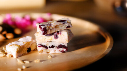 dessert shop Nutty nougat Delicious nougat stacked on a wooden plate, garnished with nuts and...