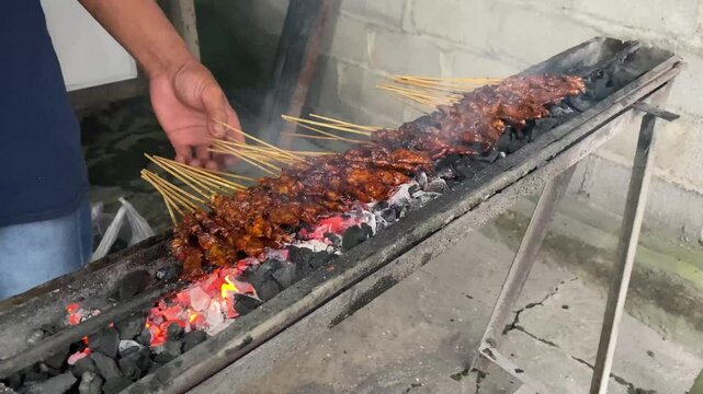Chicken satay is being grilled on the stove