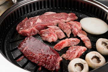 Beef, mushrooms and onions are grilling on the grill.
