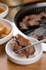 Grilled beef being dipped in salt

