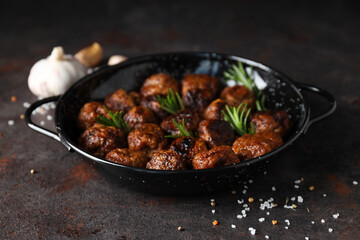 Meatballs in a black bowl on a dark background