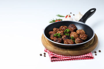Meatballs in a pan with spices on a white background