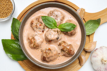 Meatballs in a bowl with leaves on a light background