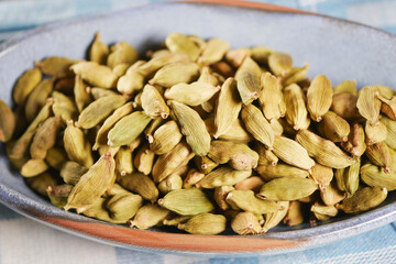 Freshly harvested green cardamom pods in a bowl for spice preparation