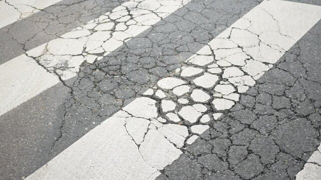 Cracked crosswalk in urban setting shows signs of neglect
