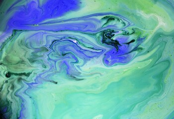 Abstract green and blue background. The acrylic paint flows and mixes freely, creating a whimsical pattern. The background for the laptop screen, the pattern for the fabric. The background.