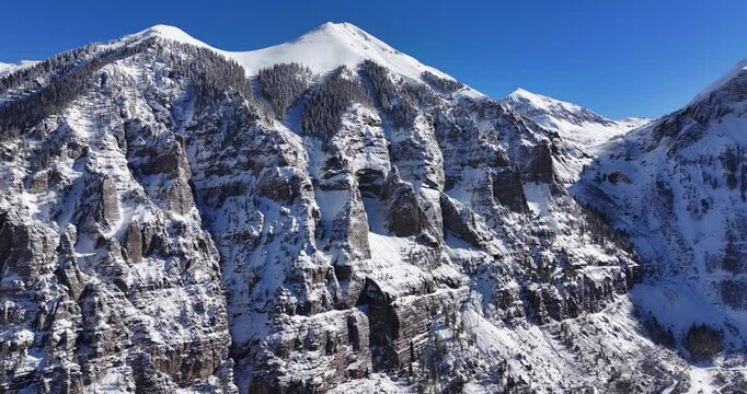 An unworldly aerial drone shot of the extreme Kroger Via Ferrata cliff face and the Black Bear pass switchbacks, slowly tracking backward over the Telluride Valley floor in Western Colorado.